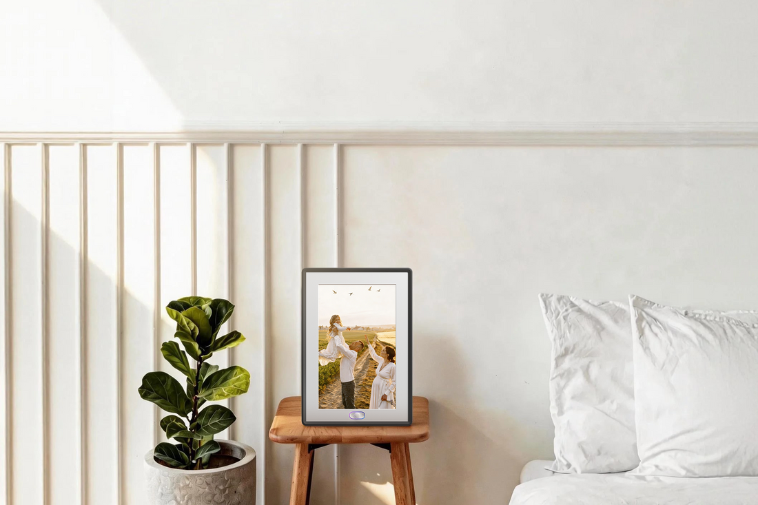 Sleek Amivo digital photo frame for grandparents on a bedside table, featuring an easy-to-use AI interface and high-fidelity display.