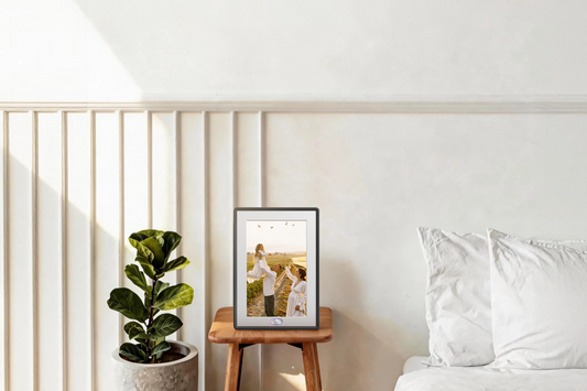 Sleek Amivo digital photo frame for grandparents on a bedside table, featuring an easy-to-use AI interface and high-fidelity display.