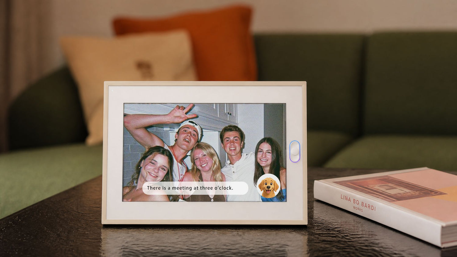 A hand pressing the side button on a smart picture frame showing family portraits, one of the best digital frame picks for gifting.
