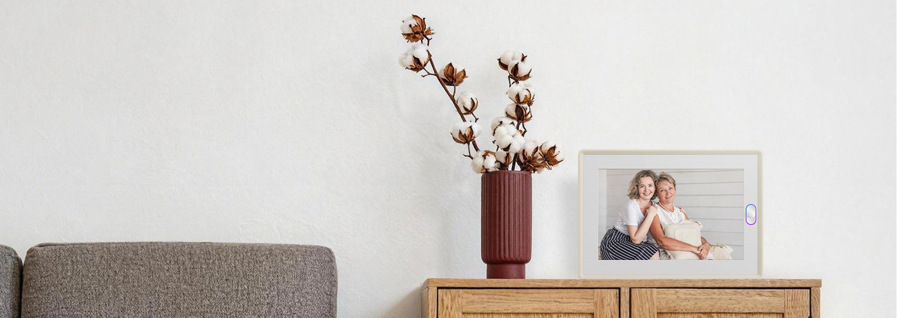 A smart picture frame displaying a family photo on a wooden cabinet, serving as a beautiful mother's day gift.