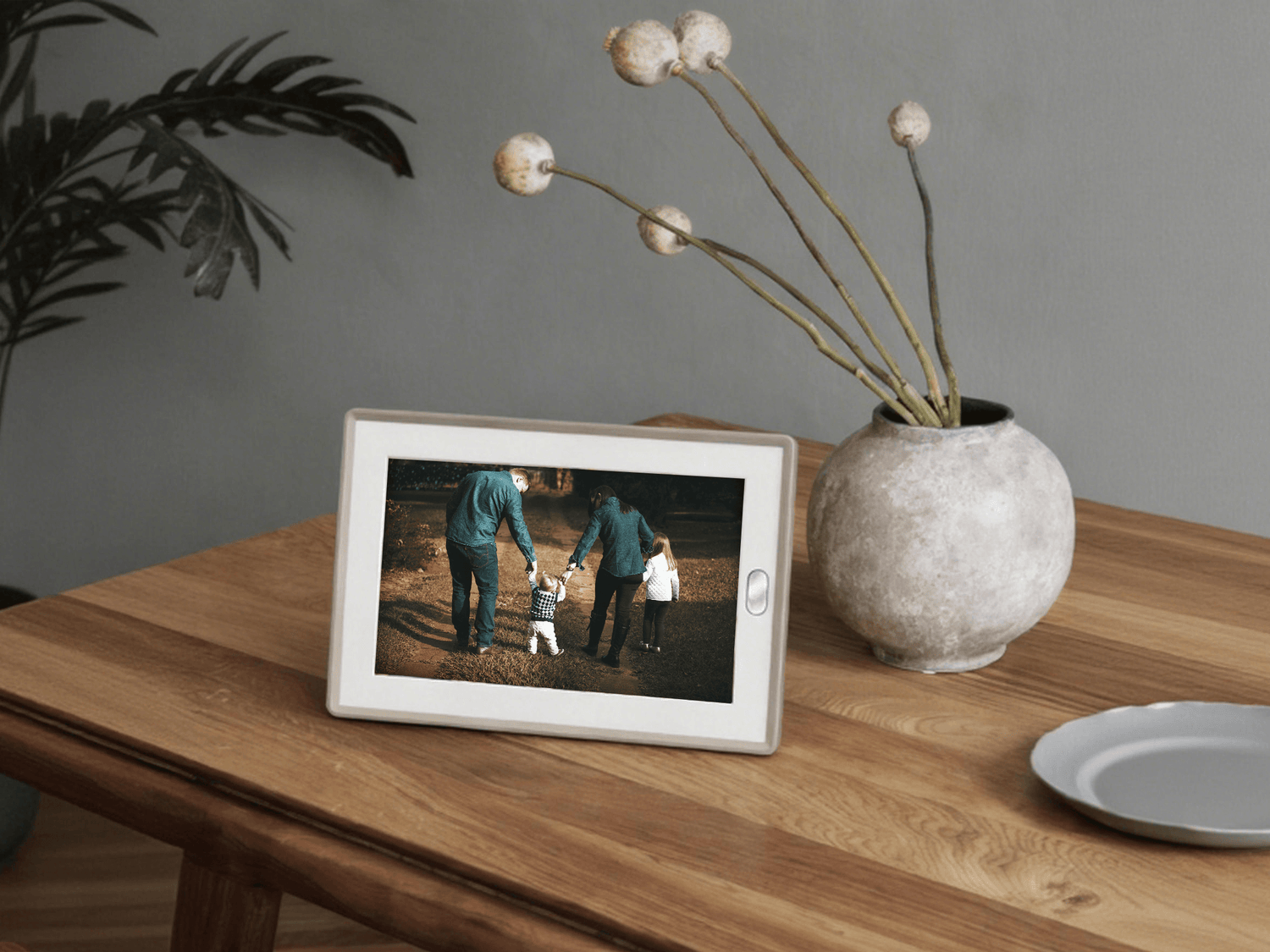 The AmivoFrame conversational AI smart photo frame displaying a happy family portrait on a wooden table